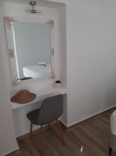 a mirror and a chair in a room at Flora Suite in Naoussa Paros in Naousa