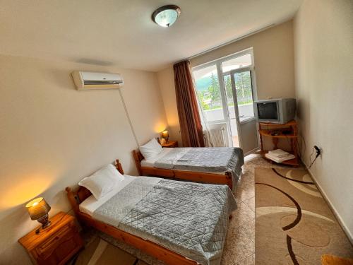 a small room with two beds and a television at MOTEL INTERNATIONAL in Berkovitsa
