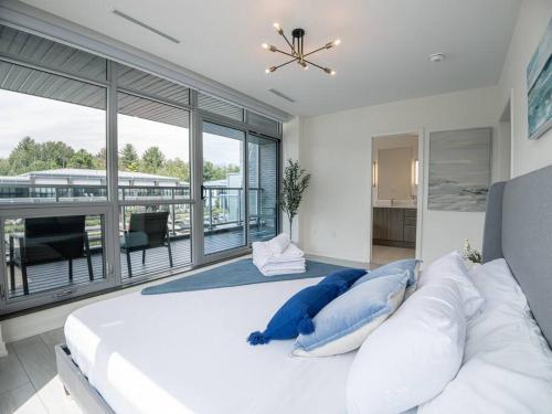 a bedroom with a large white bed with blue pillows at Casa Lago 5 Bed Waterfront House in Innisfil