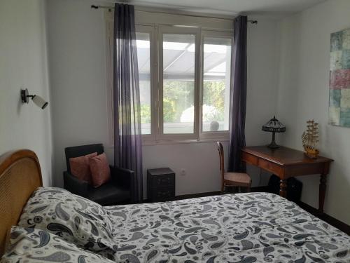 a bedroom with a bed and a desk and a window at MAISON GRAND LUXE PROX. STVAAST LA HOUGUE-BARFLEUR in Saint-Pierre-Église