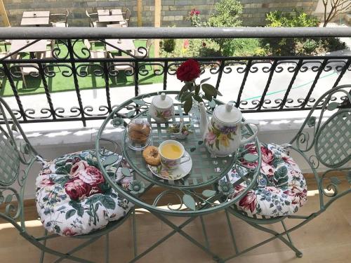 a glass table with cups and teapots on a balcony at Villa Qeli in Gjirokastër
