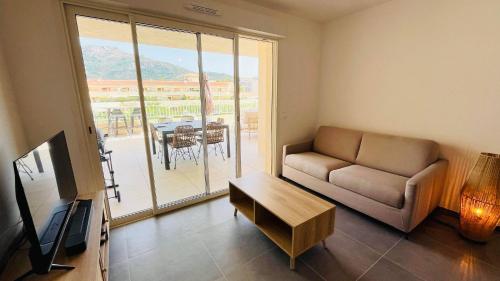 a living room with a couch and a table at Appartement T3 A Marina 2 LUMIO in Lumio