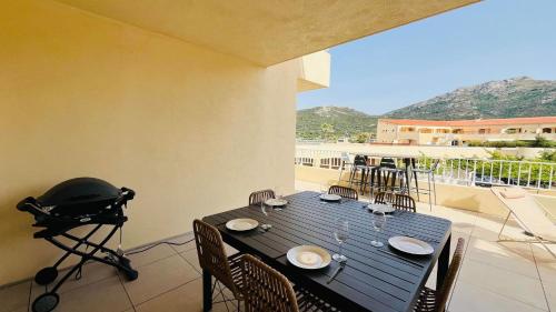 a black table with chairs and a camera on a balcony at Appartement T3 A Marina 2 LUMIO in Lumio