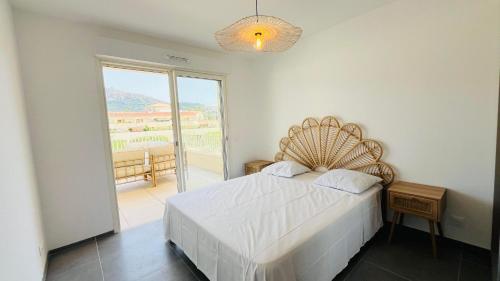 une chambre avec un lit et une grande fenêtre dans l'établissement Appartement MARINA 2 LUMIO, à Lumio