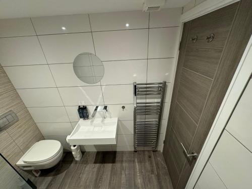 a bathroom with a toilet and a sink and a shower at Southgate Luxury Apartments-Jaquzzi Bath-Private Parking- 2 Min M62 in Elland