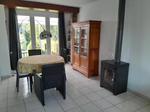 a dining room with a table and a wood stove at MAISON GRAND LUXE PROX. STVAAST LA HOUGUE-BARFLEUR in Saint-Pierre-Église