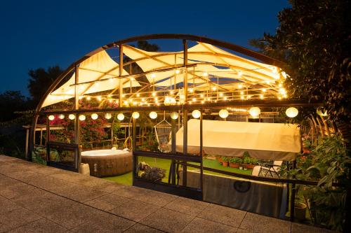 a greenhouse with lights in a garden at night at Chiwi's Home in Vado Ligure