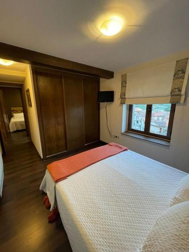 a bedroom with a large white bed with a window at El Rencuentro in Villarejo del Valle