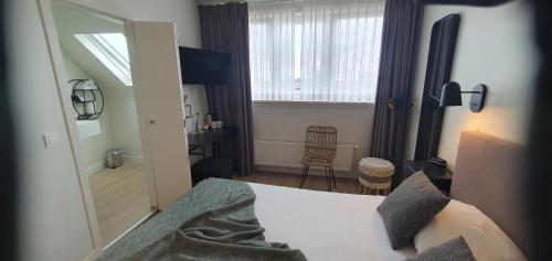a bedroom with a bed and a mirror and a desk at Hotel du Bassin in Ostend