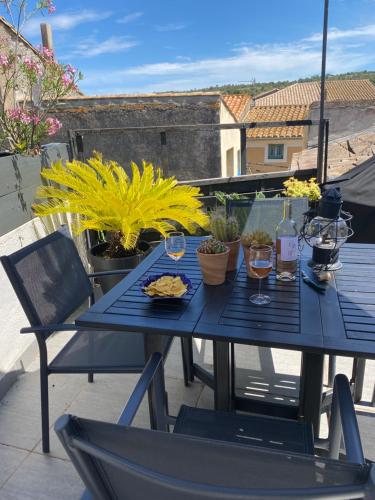 une table bleue avec des verres de vin sur un balcon dans l'établissement Maison de village sa charmante chambre avec terrasse, à Fleury