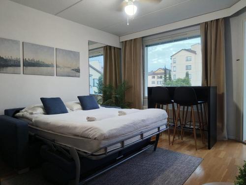 a bedroom with a bed and a large window at EP City Suite - Sauna, Balcony & Free parking in Tampere