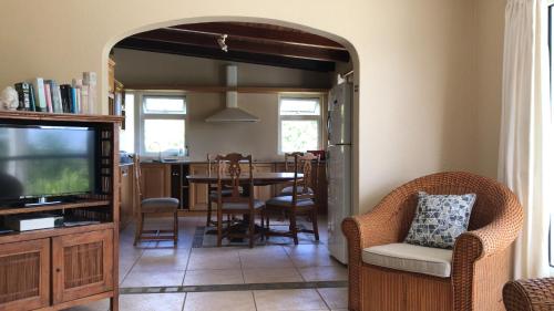 a living room with a tv and a table and chairs at Tropical Apartment in Tamarin