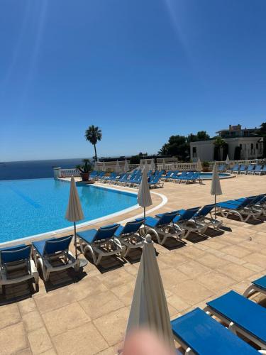 une piscine avec chaises longues et parasols dans l'établissement Villa Francia Résidence piscine tennis à 500m des plages de Cannes, à Cannes