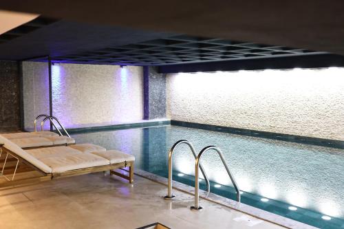 a swimming pool with two benches and a swimming pool at Cip Hotel & Spa - İstanbul Bakırköy City Center in Istanbul