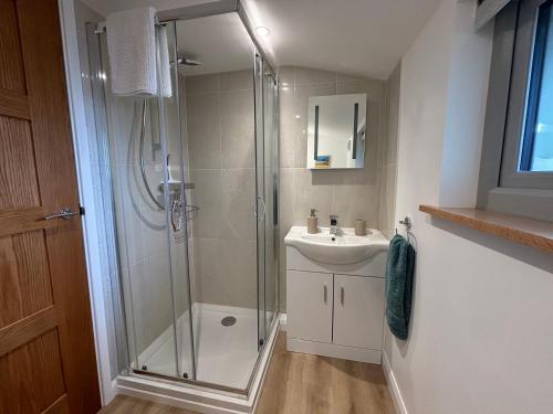 a bathroom with a shower and a sink at The Stables at Hustyn Gate in Wadebridge