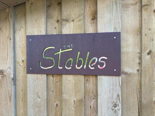 a sign on the side of a wooden wall at The Stables at Hustyn Gate in Wadebridge