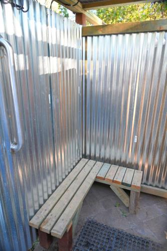 a wooden bench sitting in front of a fence at Campground at Sequoia Mountain Farms - Bring Your Own Tent or RV - No Bedrooms or Beds Provided in Miramonte