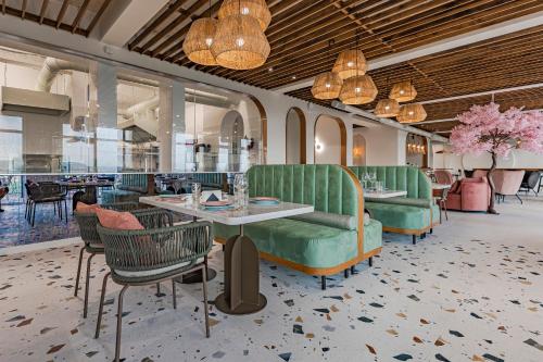 a restaurant with green furniture and tables and chairs at Casa Deniso - The Home of Chill in Byala
