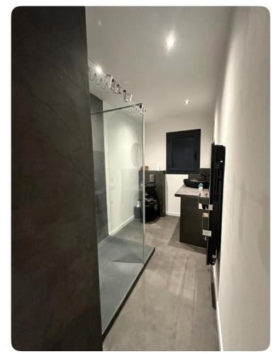 une salle de bain avec une porte de douche en verre et une cuisine dans l'établissement Casa Tony, à Ogliastro