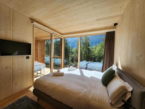 a bedroom with a large bed and a large window at Zoo des Marécottes Boutique Hôtel in Les Marécottes