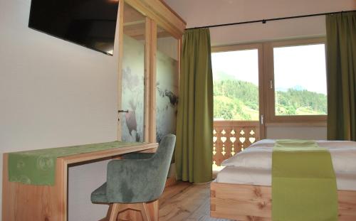 a bedroom with a bed and a desk with a chair at Hinkerhof in Schladming