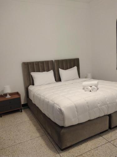 a bed with a wooden headboard and white pillows at Hotel La Casa Blanca in Tetouan