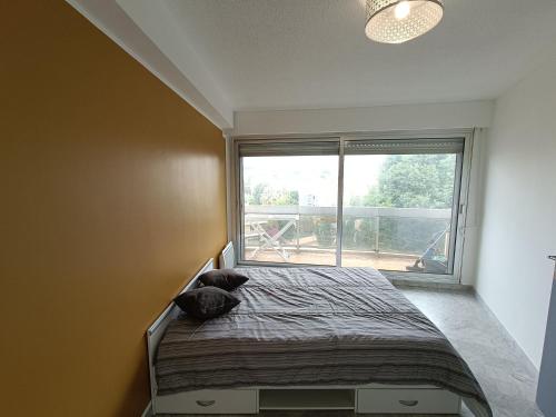 une chambre avec un lit avec une grande fenêtre dans l'établissement appartement Antibes Juan les Pins, à Antibes
