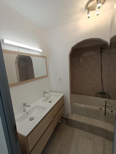 une salle de bain avec un lavabo et une baignoire dans l'établissement appartement Antibes Juan les Pins, à Antibes