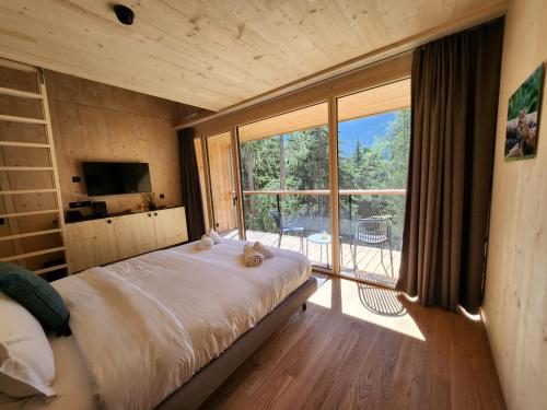 a bedroom with a bed and a large window at Zoo des Marécottes Boutique Hôtel in Les Marécottes