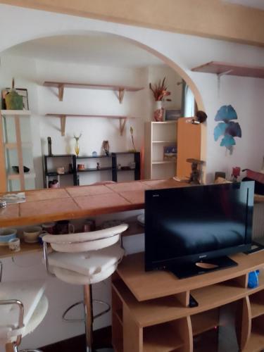 un salon avec une table et une télévision dans l'établissement Grand Studio Gentilly, à Gentilly