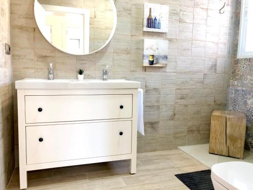 Un baño con un lavabo blanco y un espejo. en Casa Rural Miraelrio, en Corral Rubio