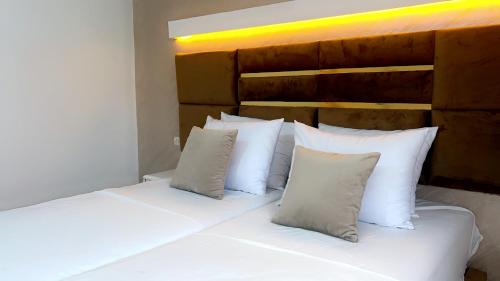 a white bed with white pillows in a bedroom at camping atlantique tan tan in Tan-Tan Plage