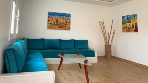 a living room with a blue couch and a table at camping atlantique tan tan in Tan-Tan Plage