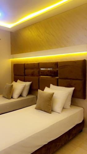two beds in a room with white pillows at camping atlantique tan tan in Tan-Tan Plage