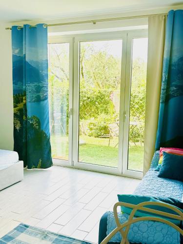 a living room with a large window with blue curtains at Dock House in Marone