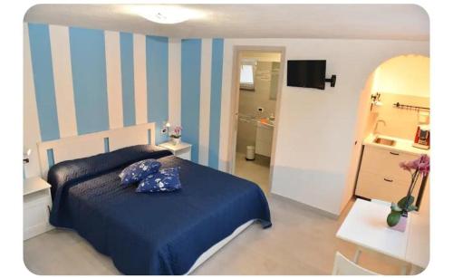 a bedroom with a blue and white striped wall at Il Leccio in Ischia