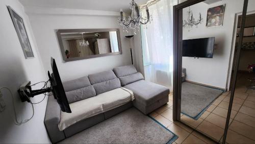 un salon avec un canapé et un miroir dans l'établissement Au coeur du village médiévale, à Roquebrune-sur Argens