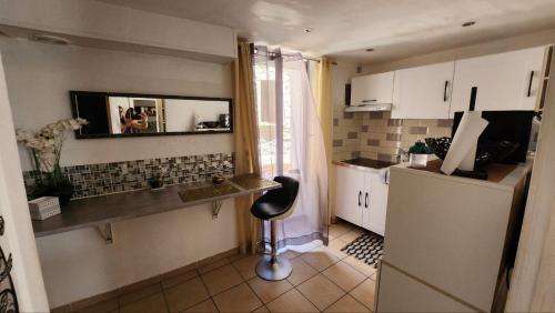 - une cuisine avec un comptoir et une chaise dans une pièce dans l'établissement Au coeur du village médiévale, à Roquebrune-sur Argens