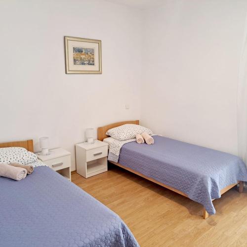 a bedroom with two beds and two night stands at Apartments Pletikosa in Brodarica