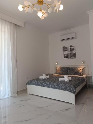 a bedroom with a bed and a chandelier at Kariani Beach Studio in Karianí