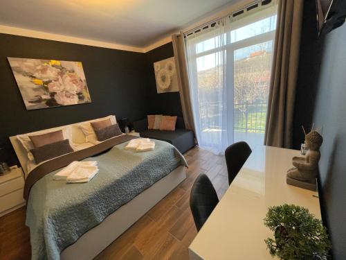 a bedroom with a bed and a table and a window at Vila Salzburg in Ocna Sibiului