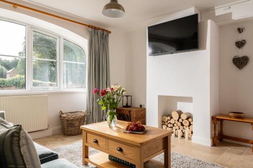 a living room with a vase of flowers on a table at May Cottage in Bridlington