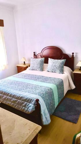 a bedroom with a large bed with a blue comforter at Residencia Beira Baixa in Monfortinho
