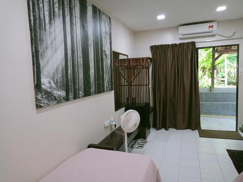 a bedroom with a bed and a window with a shower at Naura Roomstay in Kuala Tahan