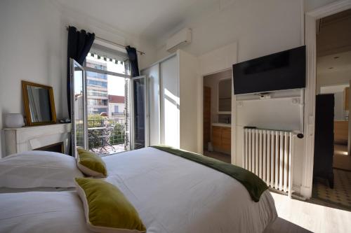 une chambre avec un grand lit blanc avec une grande fenêtre dans l'établissement Bourgeois 3CH, 2SDB, Terrasse 70m2, Palais à 400m, à Cannes