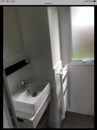 une salle de bain blanche avec un lavabo et une fenêtre dans l'établissement camping marvilla parks 4 etoiles, à Aureilhan