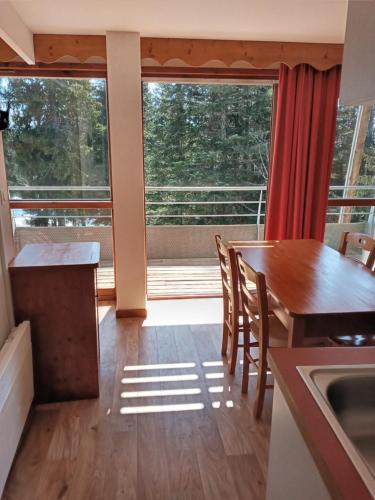 a kitchen with a table and a large window at Les Villages du Bachat à Chamrousse 1700 - Droseras D12 Classé 3 étoiles in Chamrousse