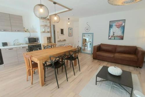 une cuisine et un salon avec une table et un canapé dans l'établissement AirBus Luxe Espace Déco Parking Gratuit, à Toulouse