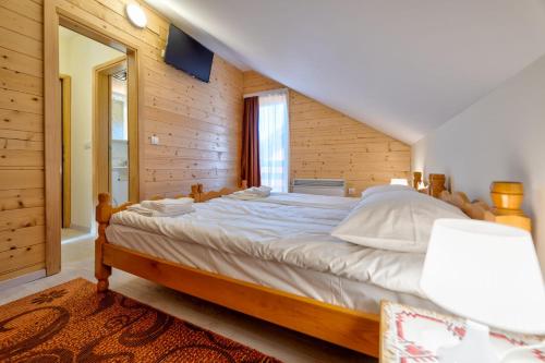 a bedroom with a large bed in a wooden room at Family 4M in Zlatibor