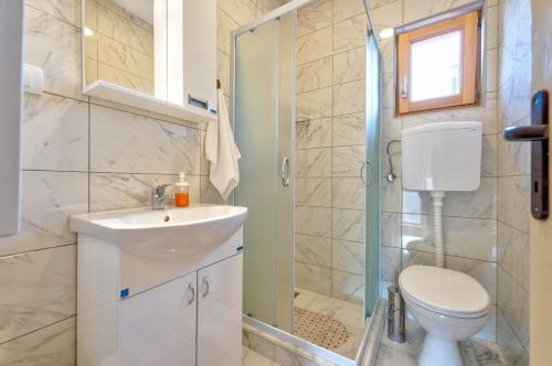 a bathroom with a toilet and a sink and a shower at Family 4M in Zlatibor